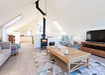 Open-plan lounge/kitchen/diner with woodburner