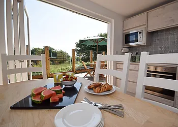 Dining area with bi-fold doors to decking and BBQ