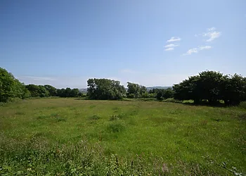 The rear of the log cabin enjoys views over fields 