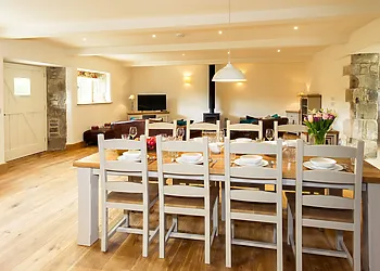 Lounge/diner with oak flooring and exposed beams