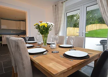Dining area through to kitchen with french doors out to garden