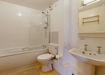Ground floor bathroom with shower over bath and WC