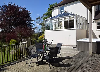 Decked area with hot tub, BBQ lodge and seating
