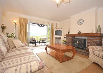 Spacious lounge with wood burner effect electric fire, leading out to the decked hot tub area