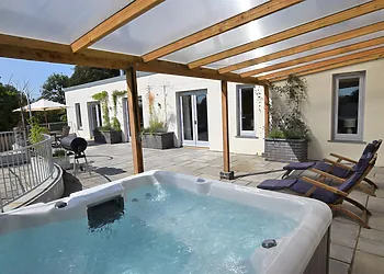 Large patio area with hot tub, sun loungers and BBQ