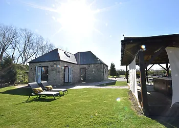 View of the cottage with Hot Tub under wooden pergola 