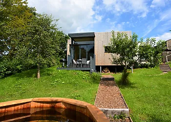A stunning eco friendly lodge set in a streamside orchard with hot tub