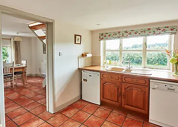 A country style kitchen with access to the dining area