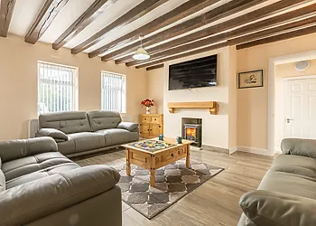 Relax in the lounge with comfortable sofas, TV and woodburner for cosy nights in 