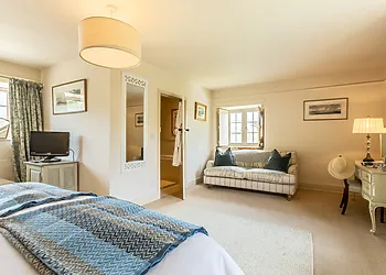 Beautifully appointed bedroom with seating area and TV