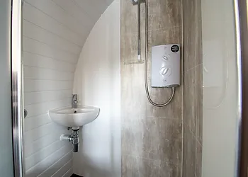The shower room with wash basin and toilet within the pod
