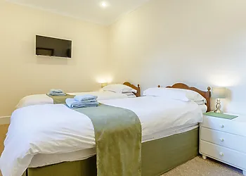 Bright twin room with wall mounted TV