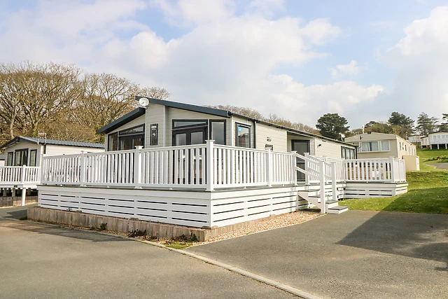 This single-storey lodge has its hot tub on gated decking, a short walk from a quiet beach