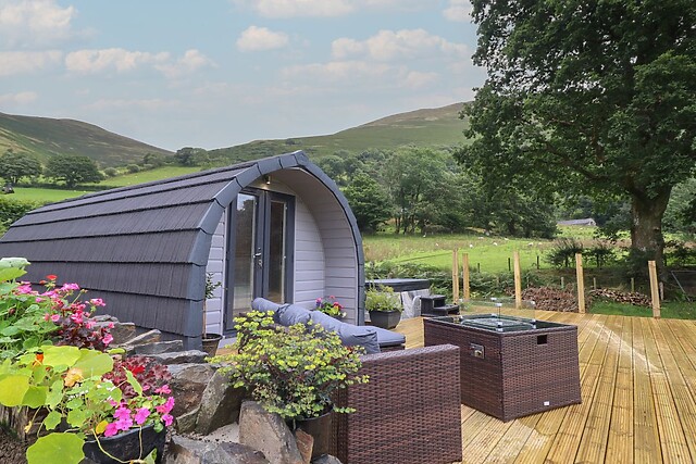 Caban Tirion is a shepherd's hut for two with a hot tub on its front decking near Dolgellau