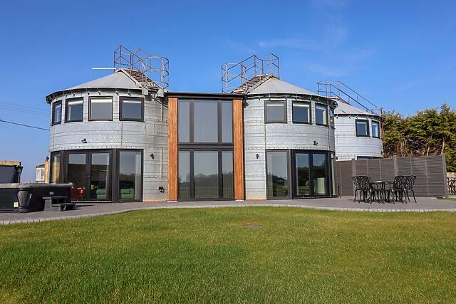 The Corn Silo is a converted pair of grain silos with a tub on the patio and farmland all round